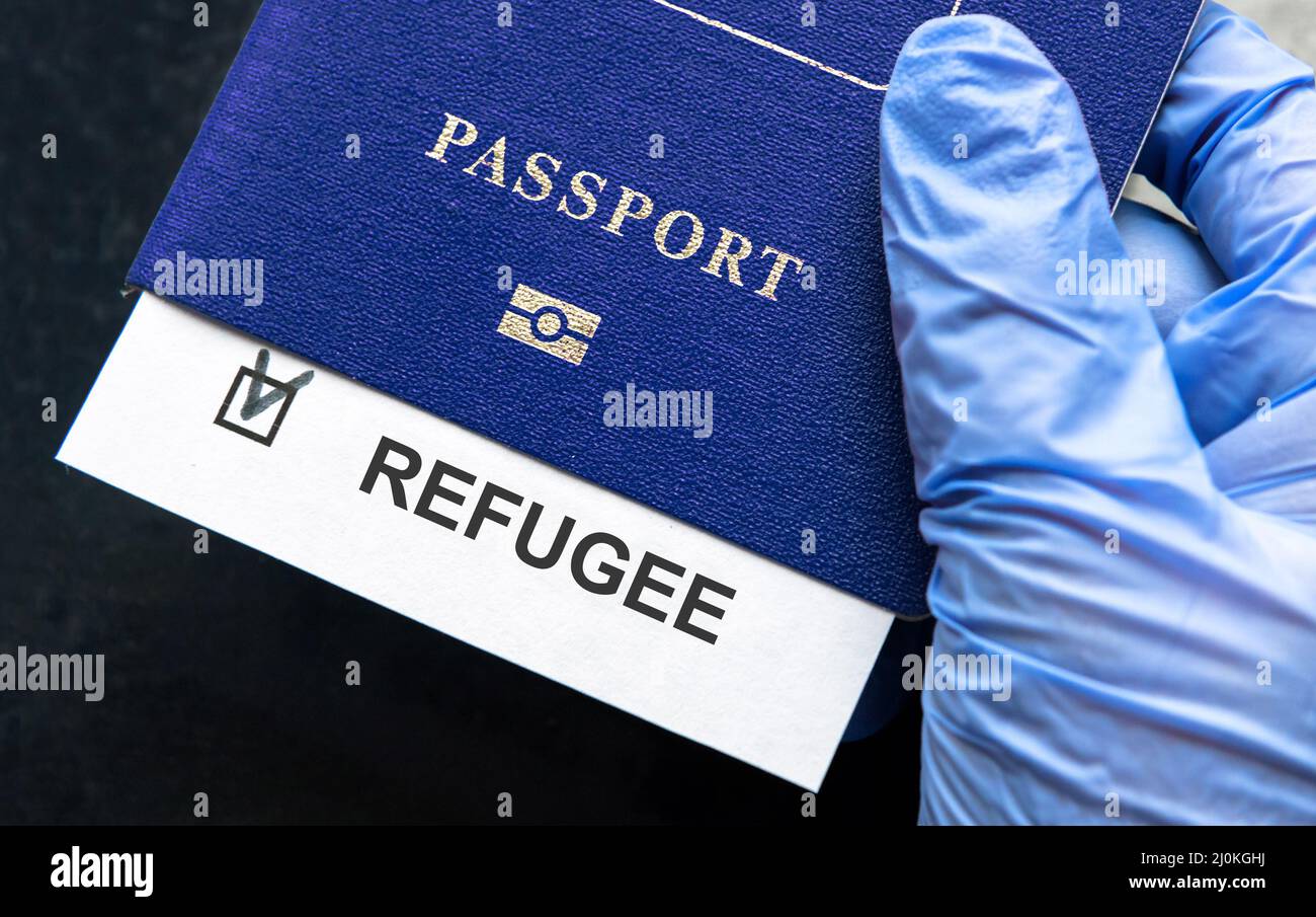 Refugee passport in hand at border control in Europe, document with refugee note close-up. Concept of Ukraine war, Syria, EU, humanitarian crisis, mig Stock Photo