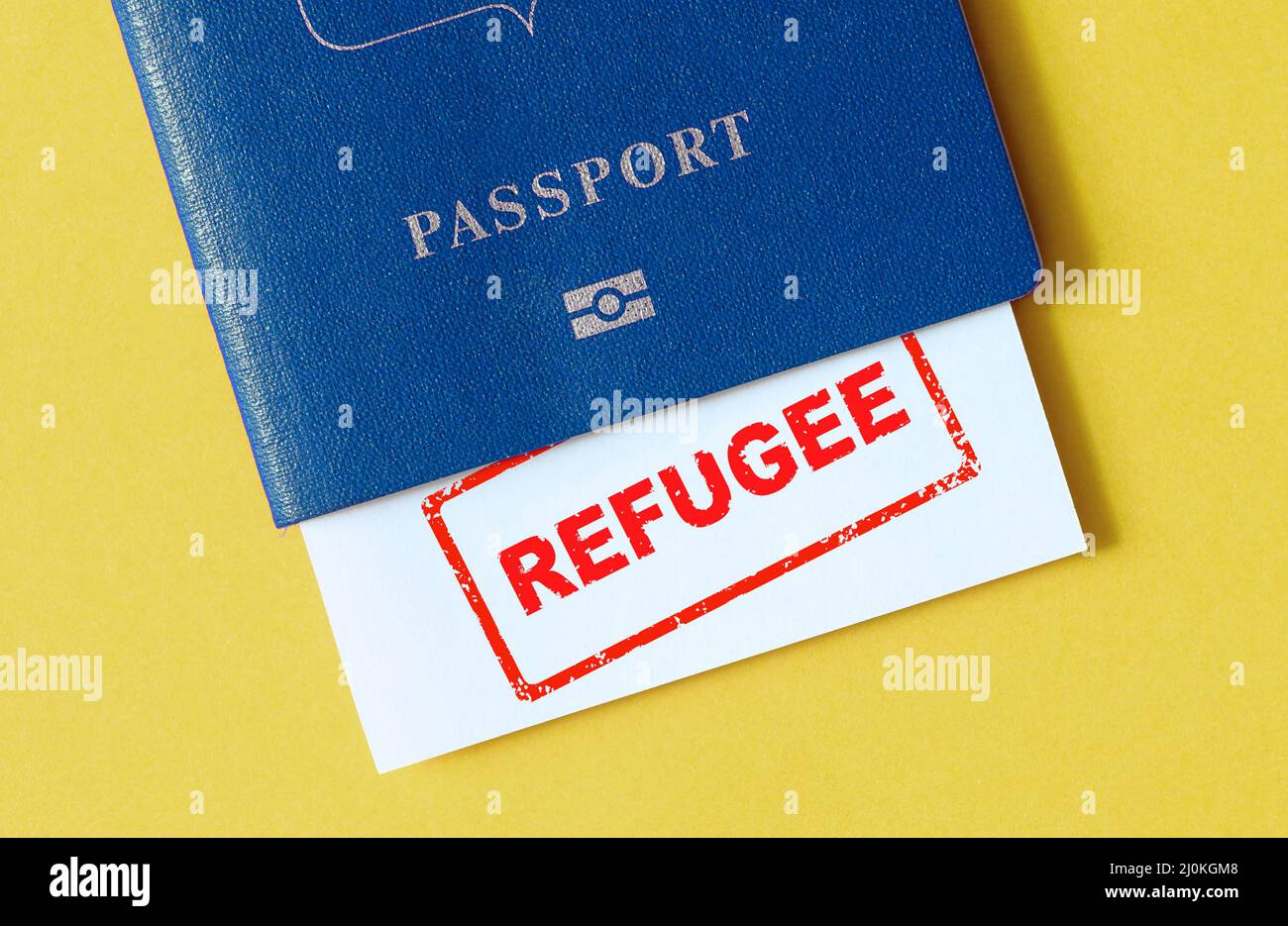 War in Ukraine and refugee concept, passport with refugee stamp on table, Ukrainian flag colors. Concept of refugees in Europe, Ukraine crisis, EU, hu Stock Photo