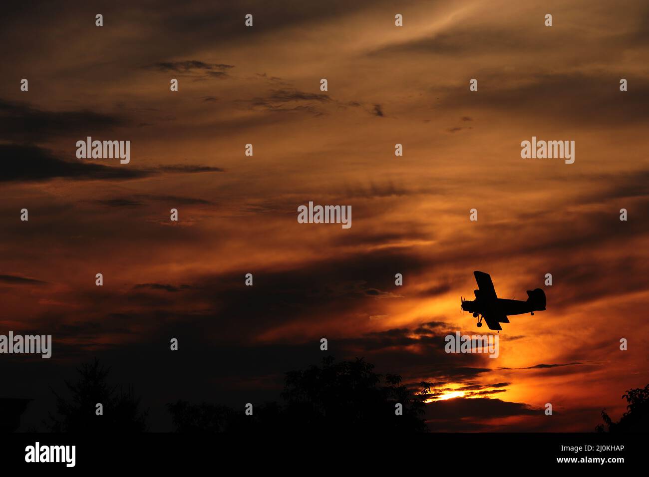 Silhouette of an aircraft flying against a beautiful sunset in Gyor ...