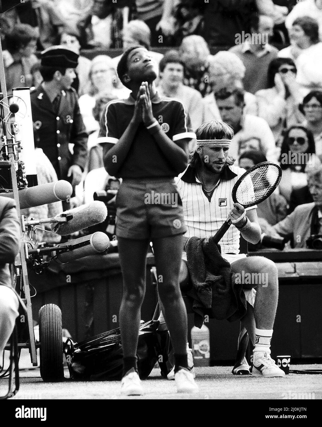 Swedish tennis player Bjorn Borg sits down between games during his  Mens Singles Semi Final match against Jimmy Connors on Centre Court, Wimbledon.Standing in front of him is  a ball boy who looks like he is praying. 2nd July 1981. Stock Photo