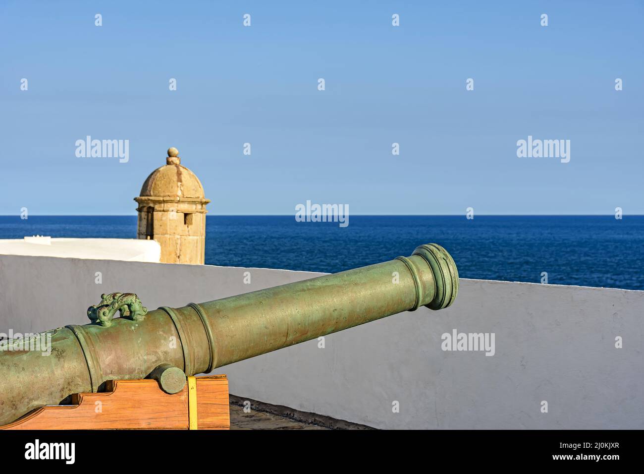 Old iron cannon and guardhouse on the walls of the historic fortress of Farol da Barra Stock Photo