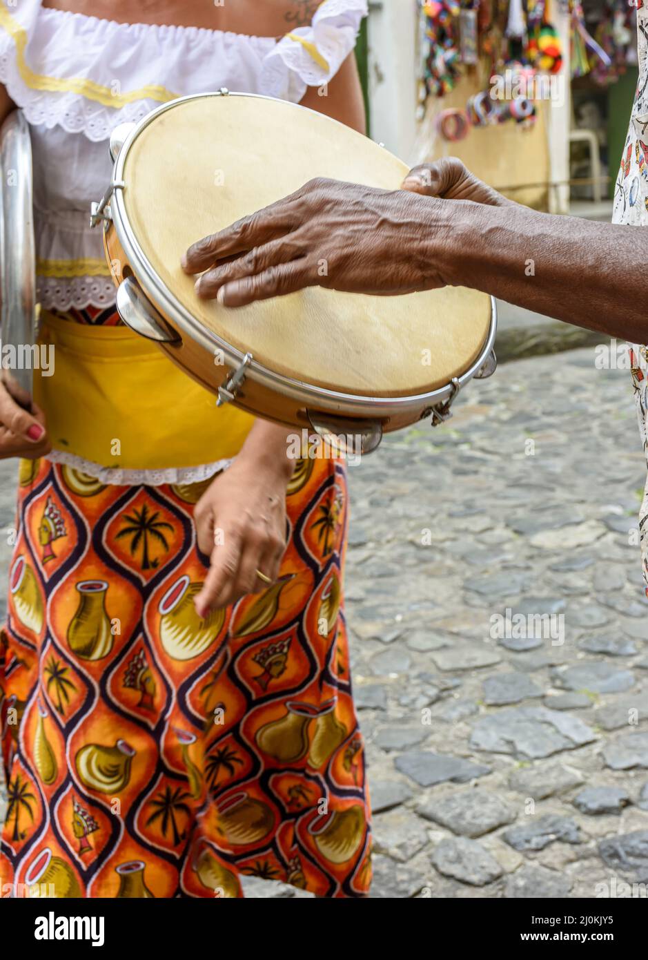 Tambourine player with a woman in typical clothes dancing in the background Stock Photo