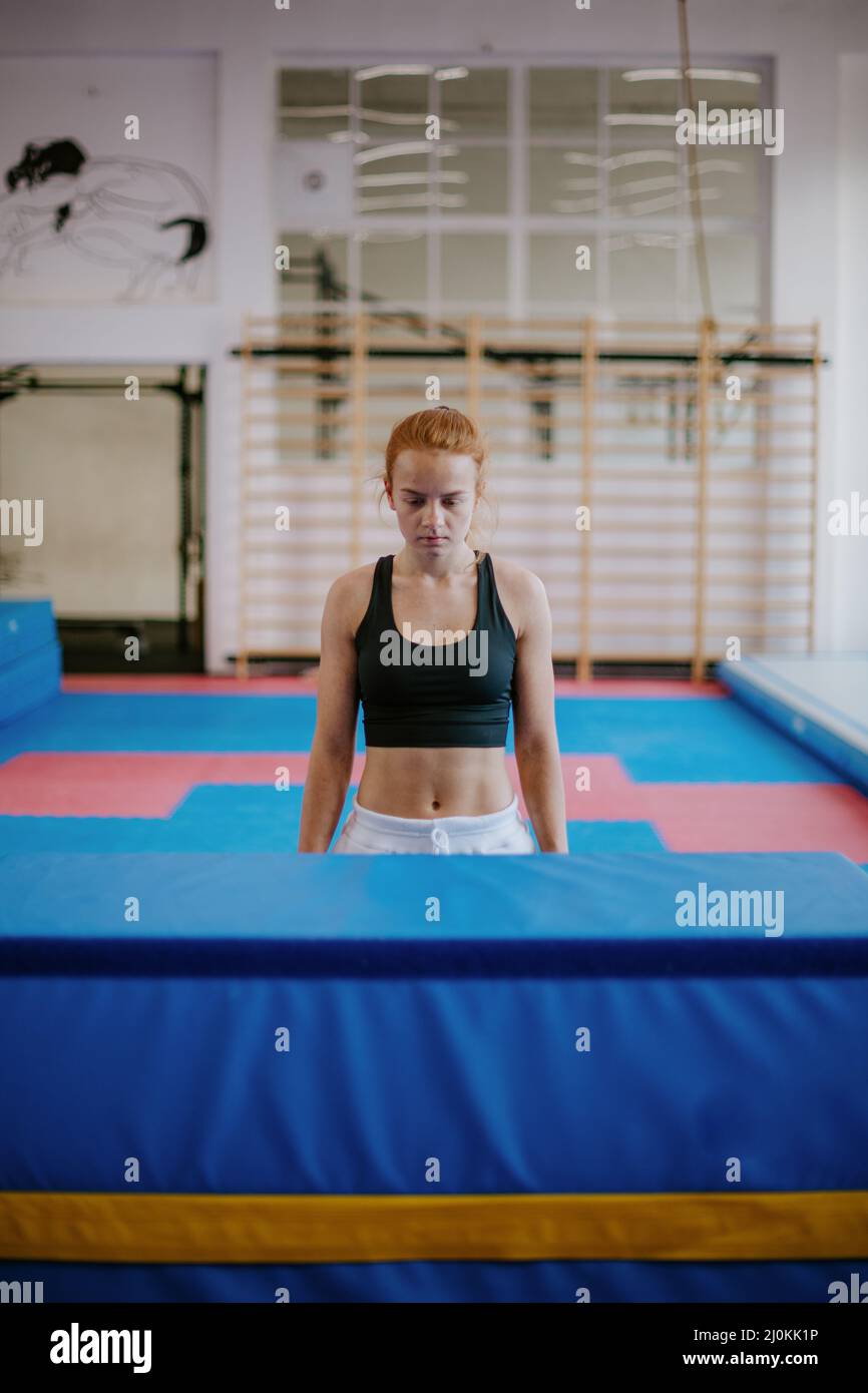 young gymnastic woman is standing in front of an obstacle and getting ready to jump Stock Photo