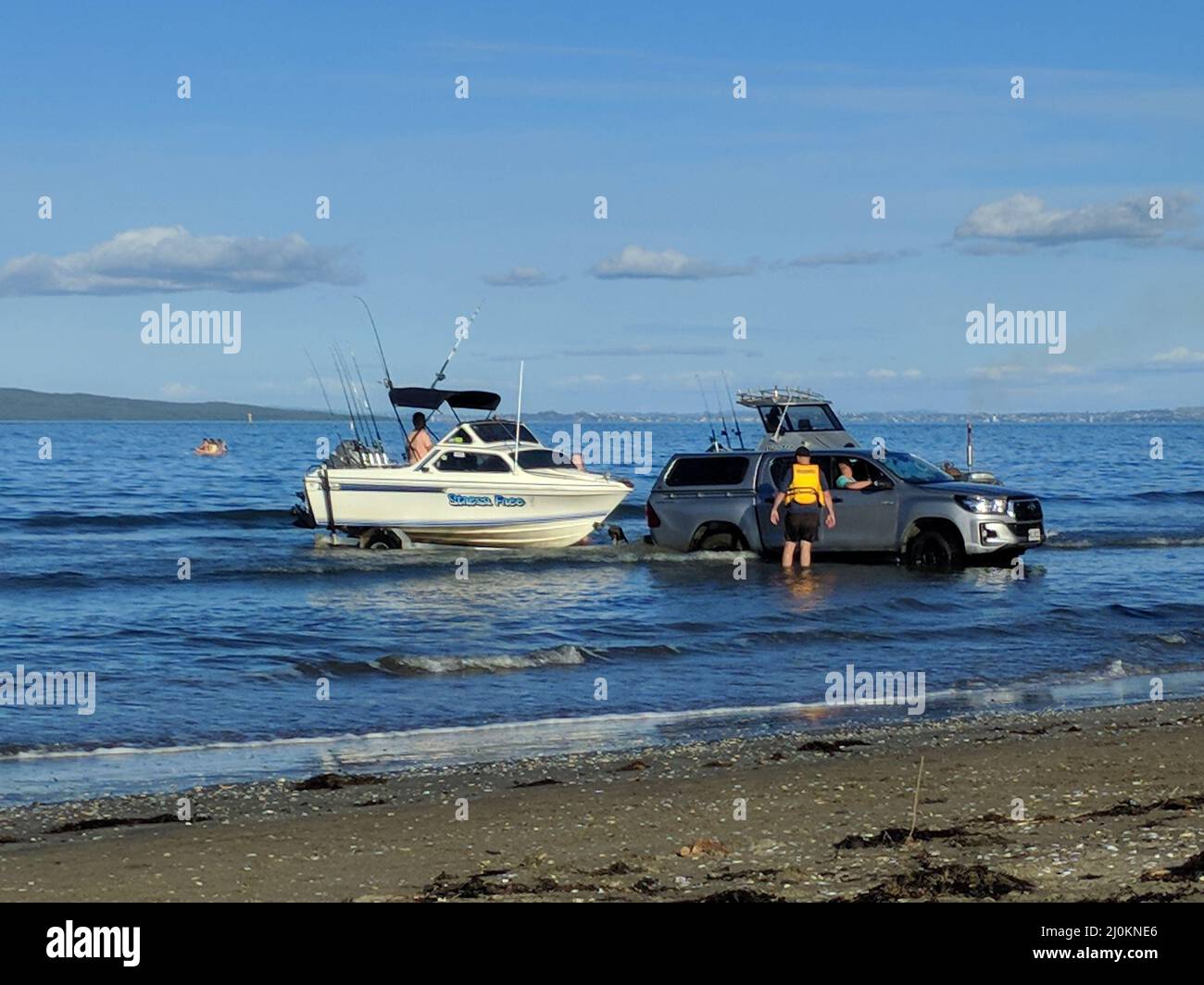 Auckland suburb, Waiake Beach, New Zealand - May 16 2020: the view of a car pulling a boat from the sea in a sunny day on May 16 2020 in Auckland, New Stock Photo