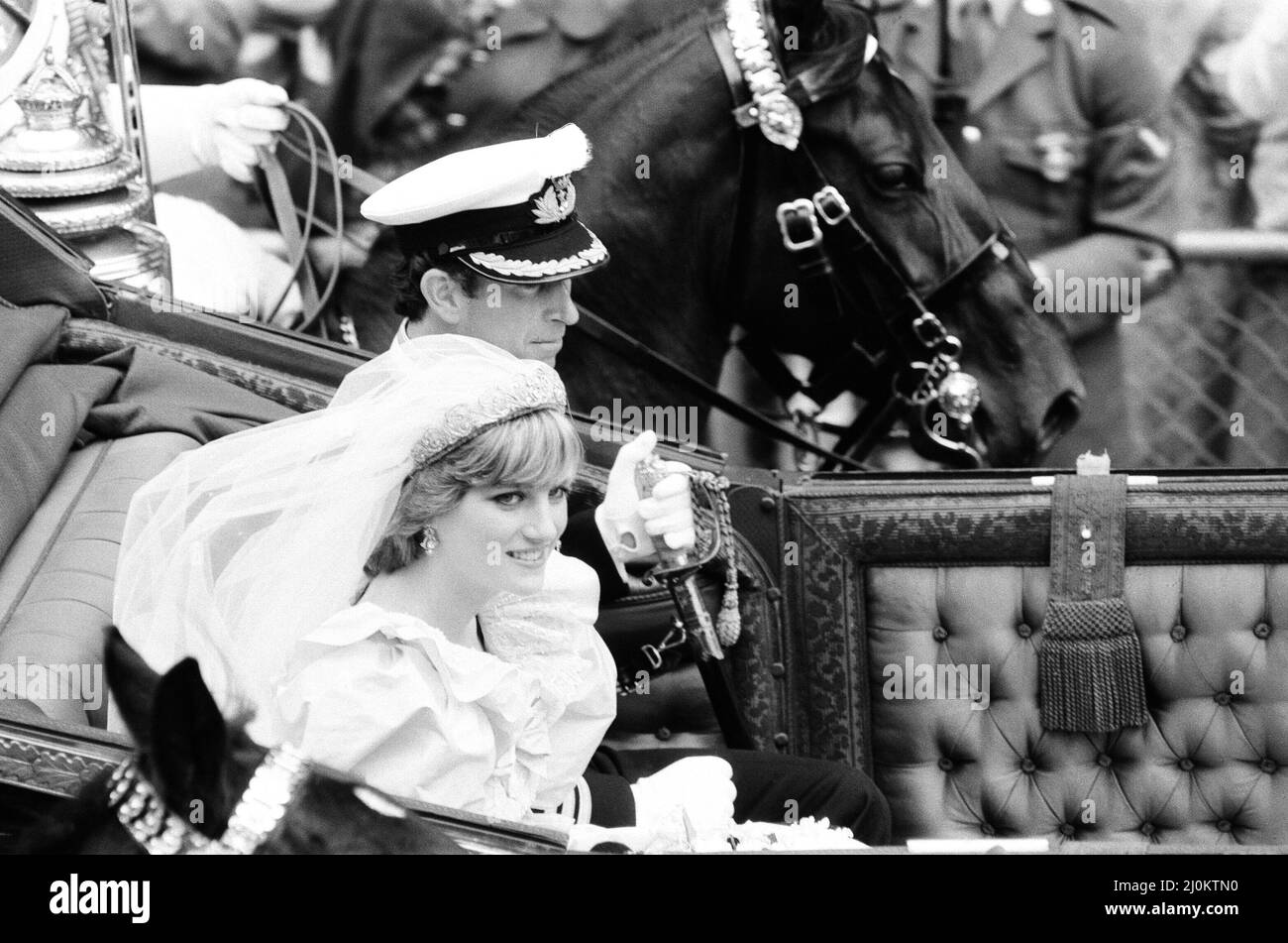 HRH Prince Charles marries Lady Diana Spencer.Picture shows the happy couple, having left St Paul's Cathedral, and now riding by carriage to Buckingham Palace.  Lady Diana's wedding dress, and it's 25 foot train has gone down as one of the most famous wedding dresses in history.  The dress was designed by David and Elizabeth Emanuel.  Picture taken 29th July 1981 Stock Photo