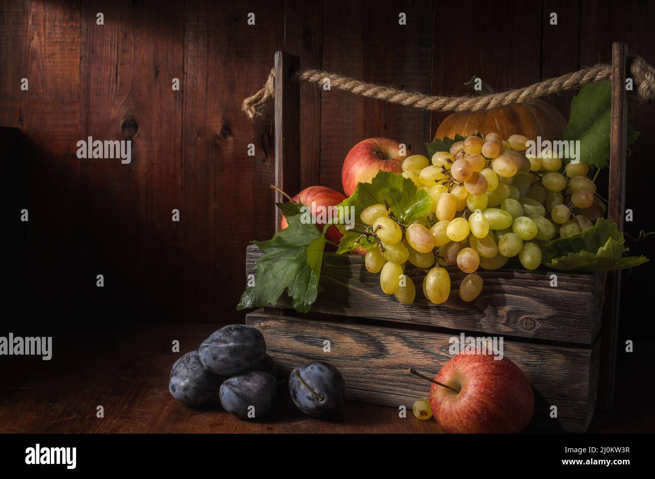 Grapes and other fruits on a dark wooden background in a rustic style Stock Photo