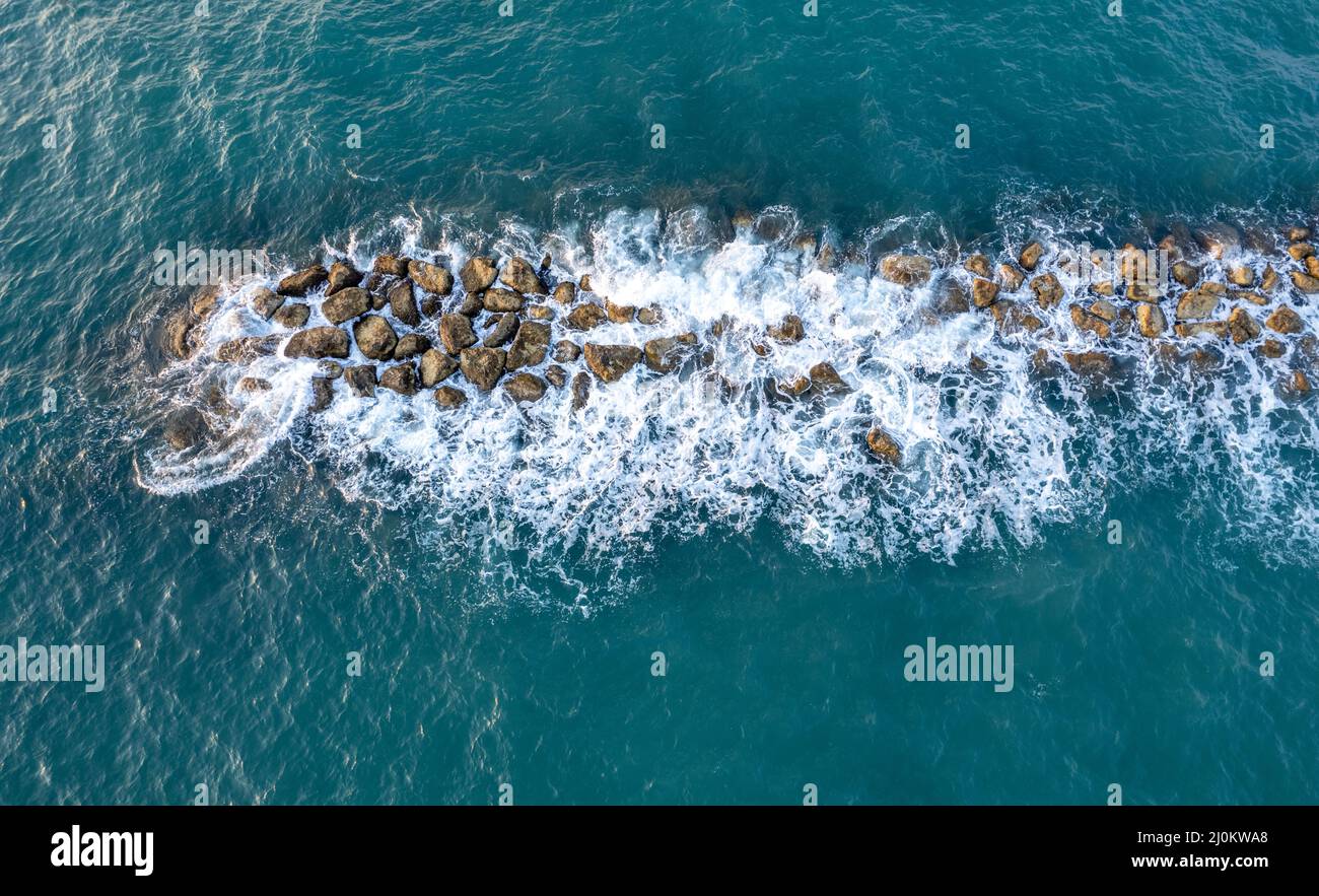Aerial view from a flying drone of blue sea water and break water. Sea wall coastline Stock Photo