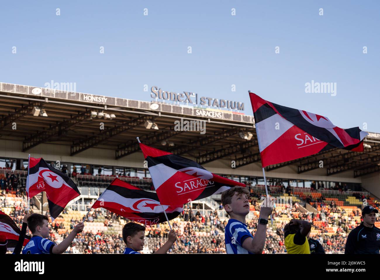 Junior Rugby Clubs wave their flags to welcome the Saracens players onto the pitch at the StoneX Stadium Stock Photo