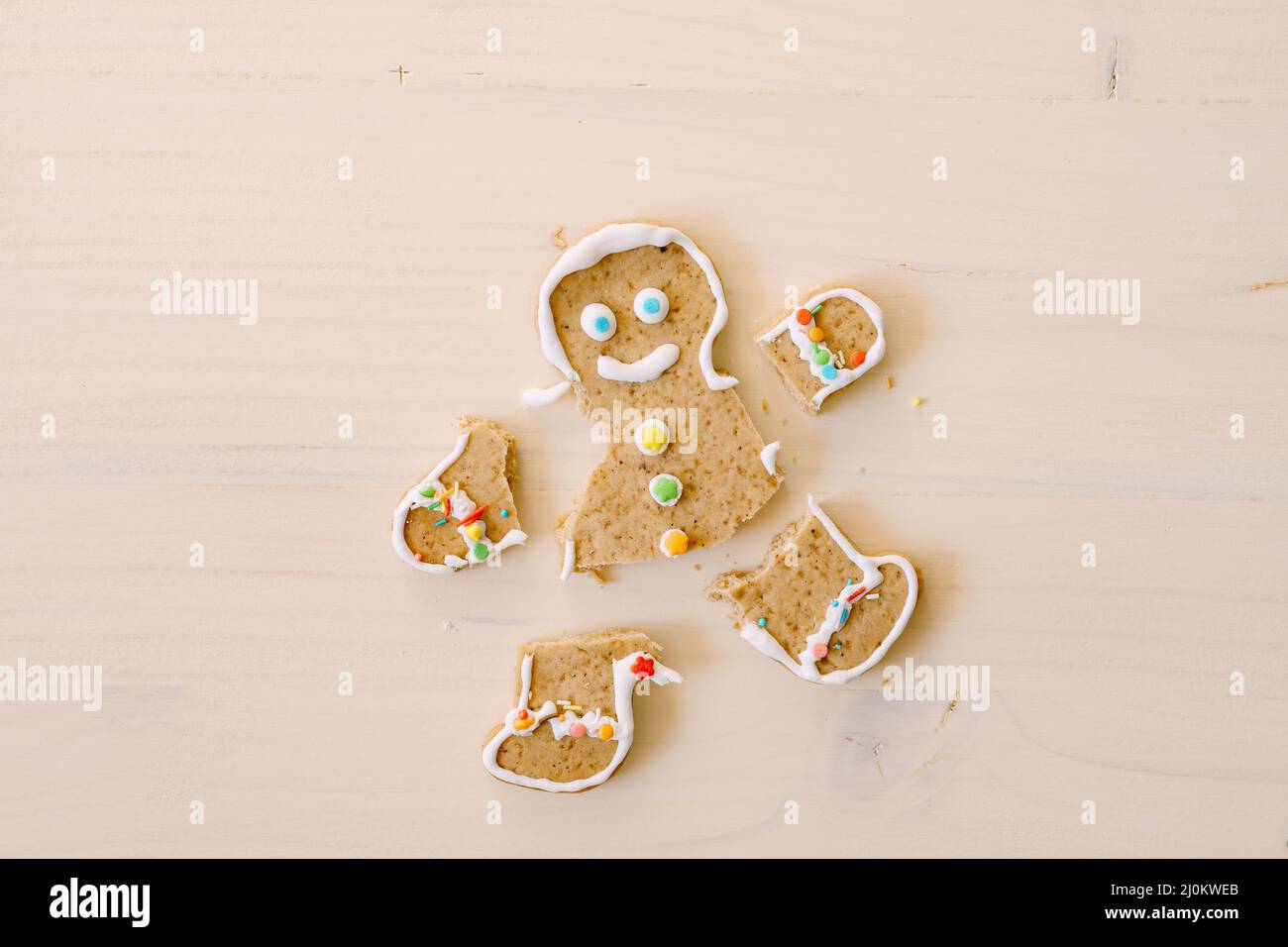 Gingerbread man with severed legs and arms. The limbs of the cookie are separated from the body. Christmas gingerbread on a whit Stock Photo