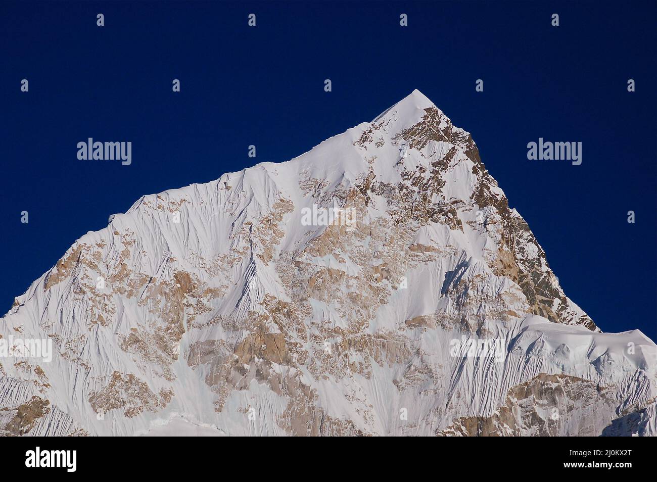 Closeup of a beautiful mountain covered in snow against a blue sky ...