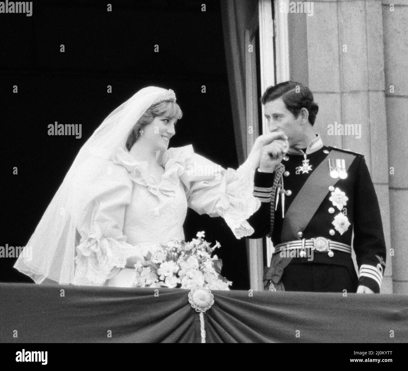 **CROPPED VERSION - ORIGINAL WIDE FRAME ALSO IN THIS SET*** Prince Charles kissed the hand of his bride, Lady Diana Spencer.  Picture taken of the happy couple on the balcony at Buckingham Palace after the wedding ceremony.  Picture taken 29th July 1981. Stock Photo