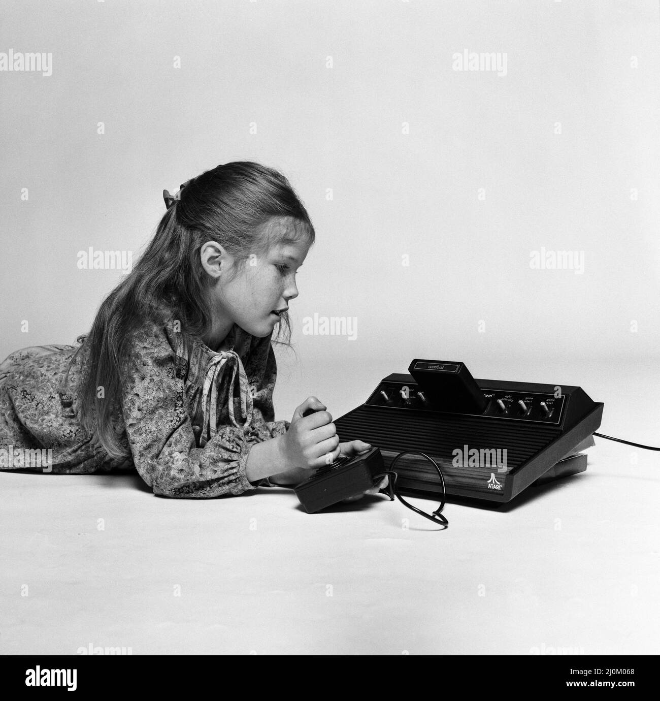 A young girl playing on the Atari 2600, a home video game console by Atari. December 1980. Stock Photo