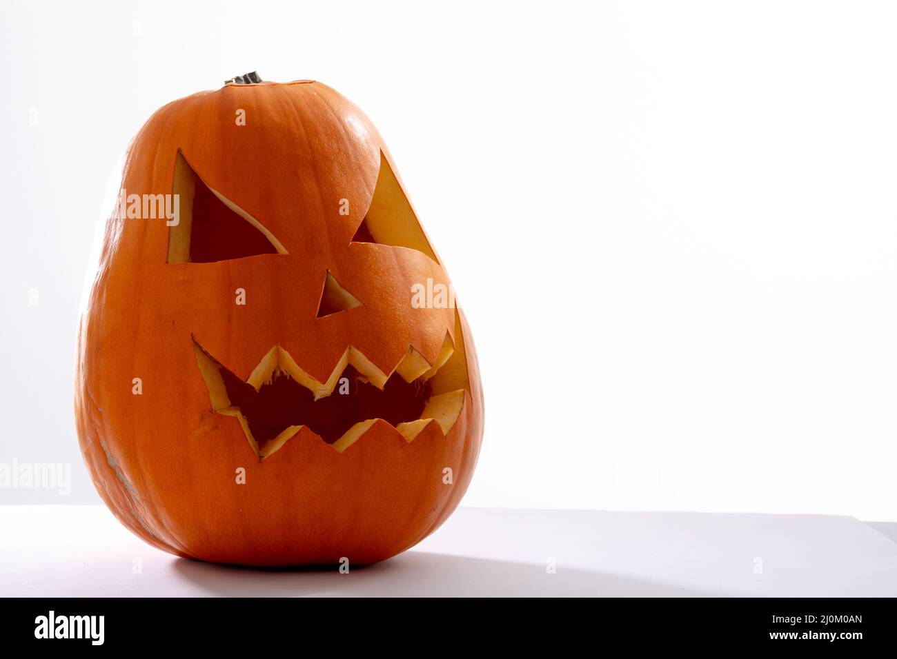 Composition of scary halloween carved orange pumpkin on white ...
