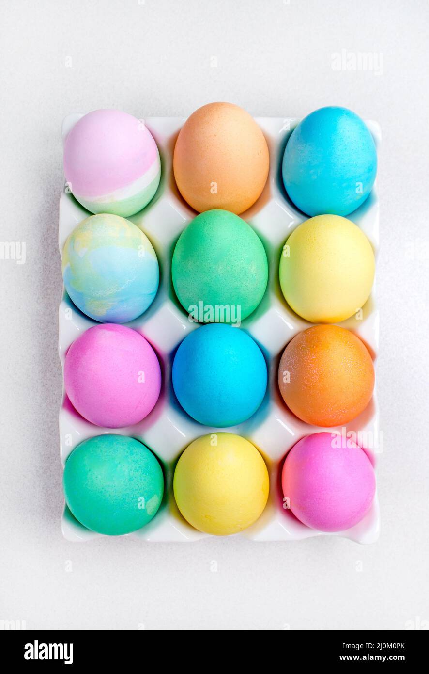 Pastel Easter eggs lying on white table. Traditional decoration Stock Photo