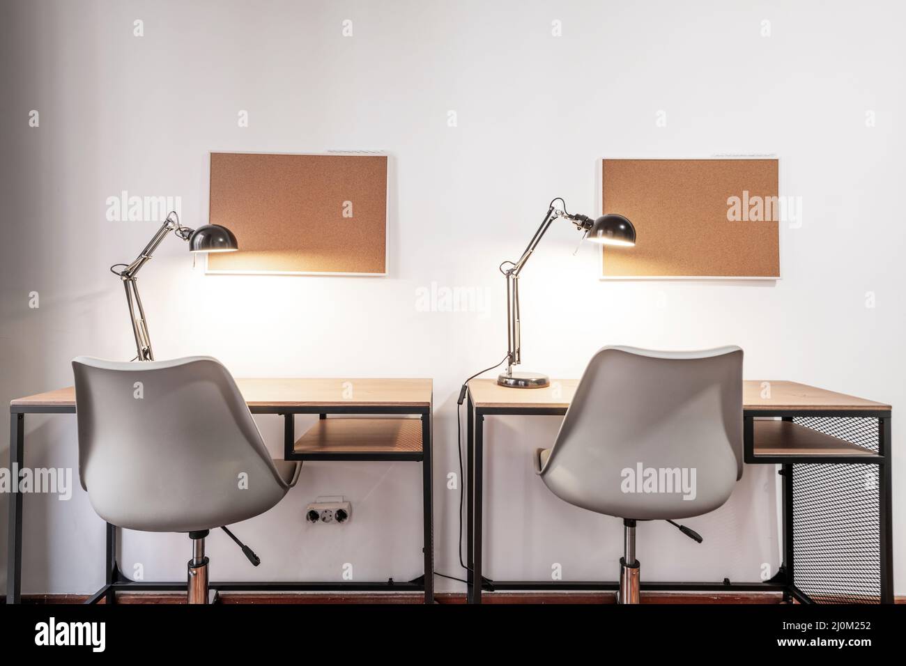 Twin double study tables with chairs, lamps and cork boards Stock Photo