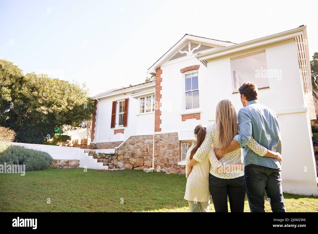 Welcome home. A family standing outdoors admiring their new home. Stock Photo