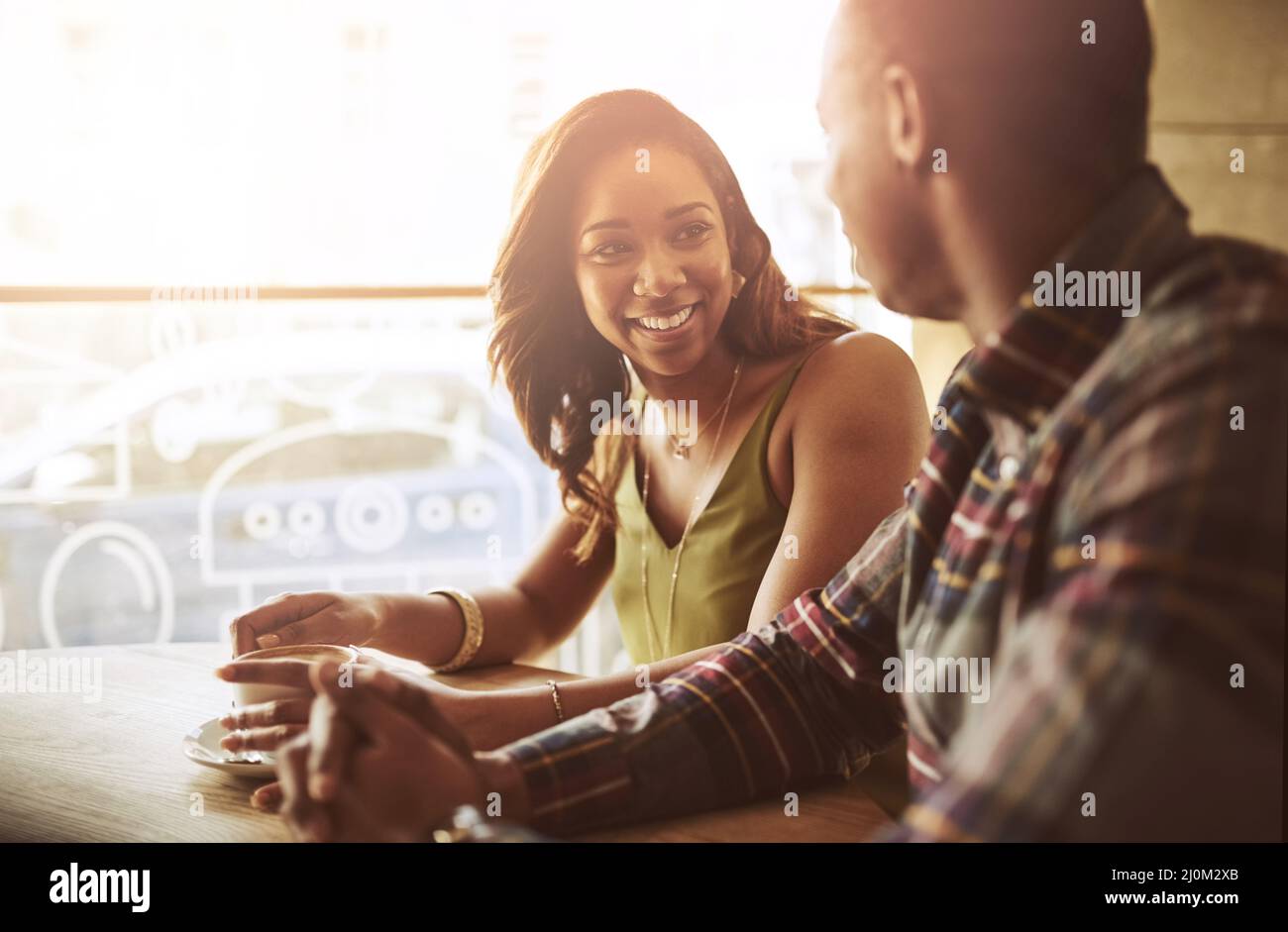 The best way to get to know each other. Shot of two friends having coffee together in a coffee shop. Stock Photo