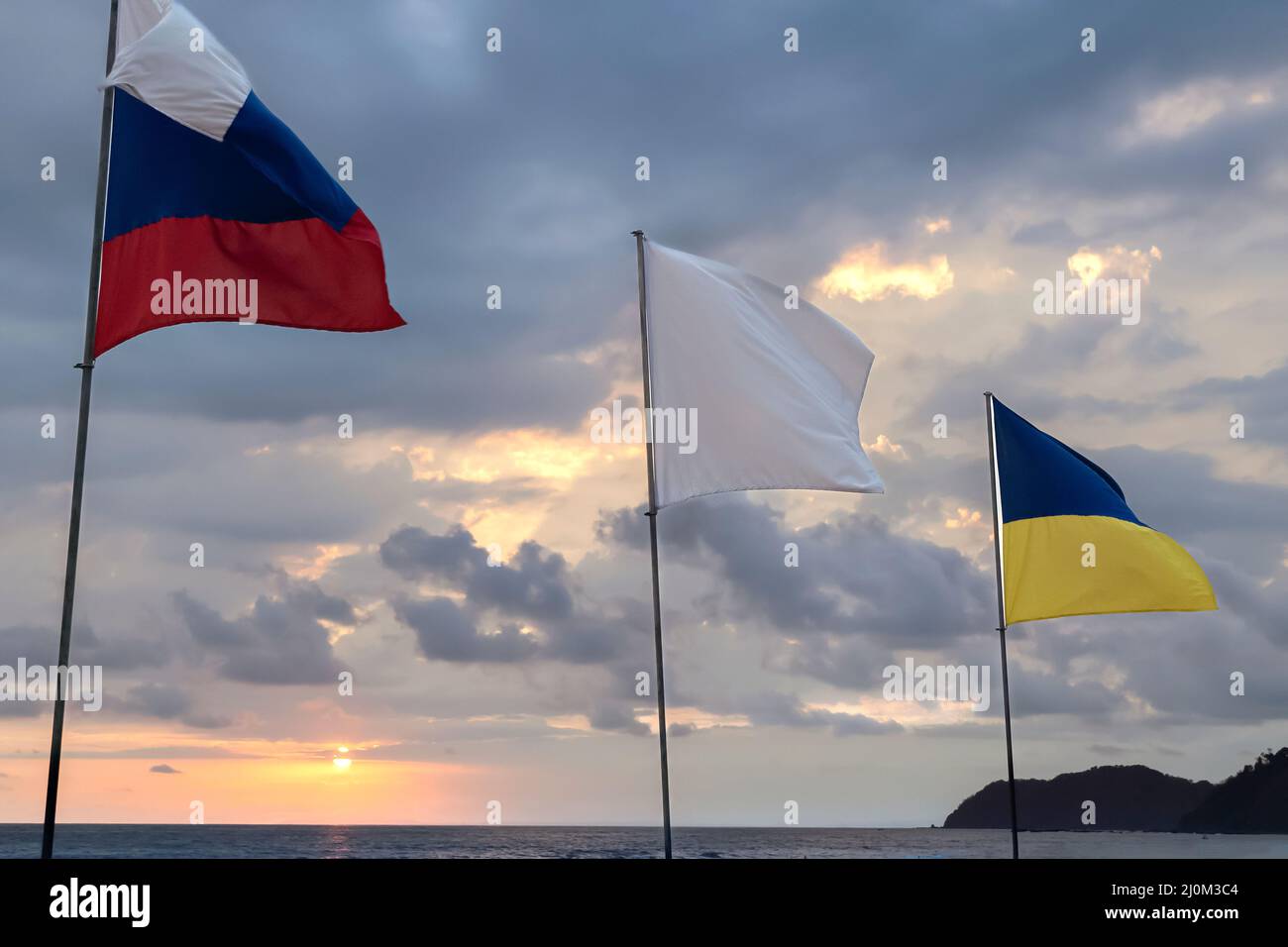 Ukrainian and Russian flags on blue and yellow sky background. Stock Photo