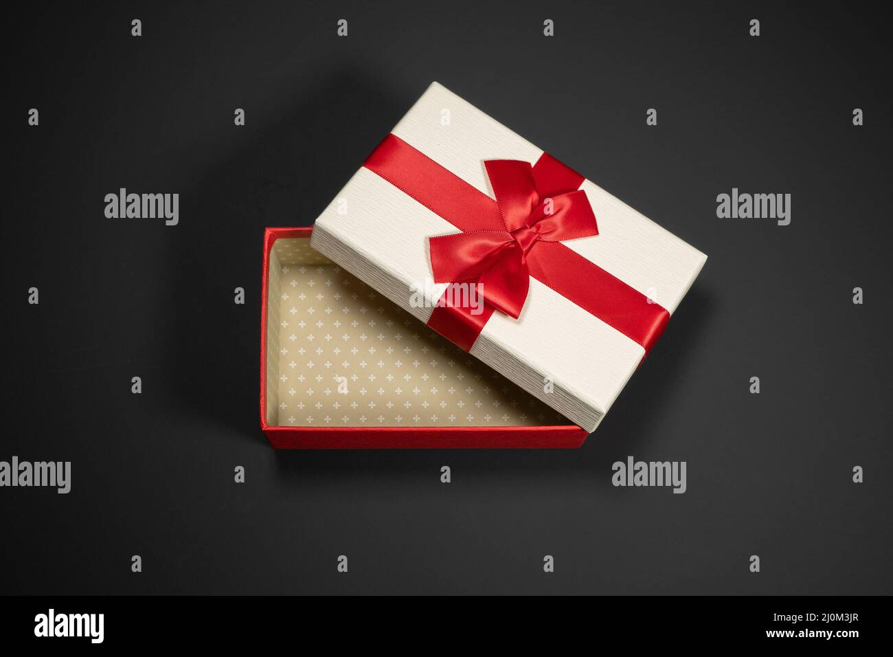 Wrapped vintage gift boxes with red ribbon bow, isolated on black Stock Photo