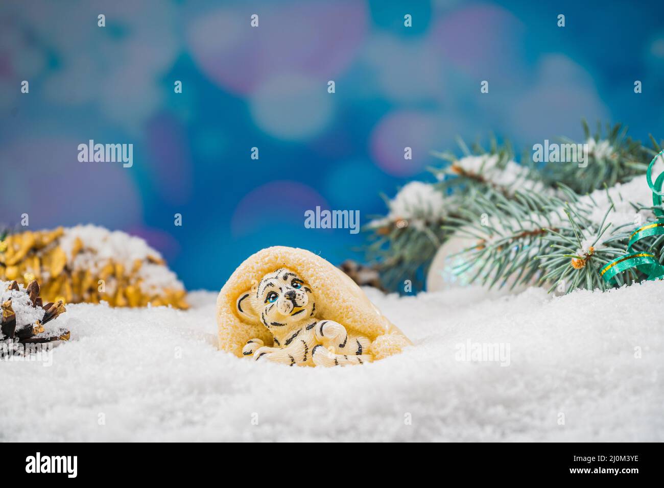 Christmas chocolate toy on snow. Chocolate toy in the shape of a tiger, symbol of the year 2022. Joyful mood. Stock Photo