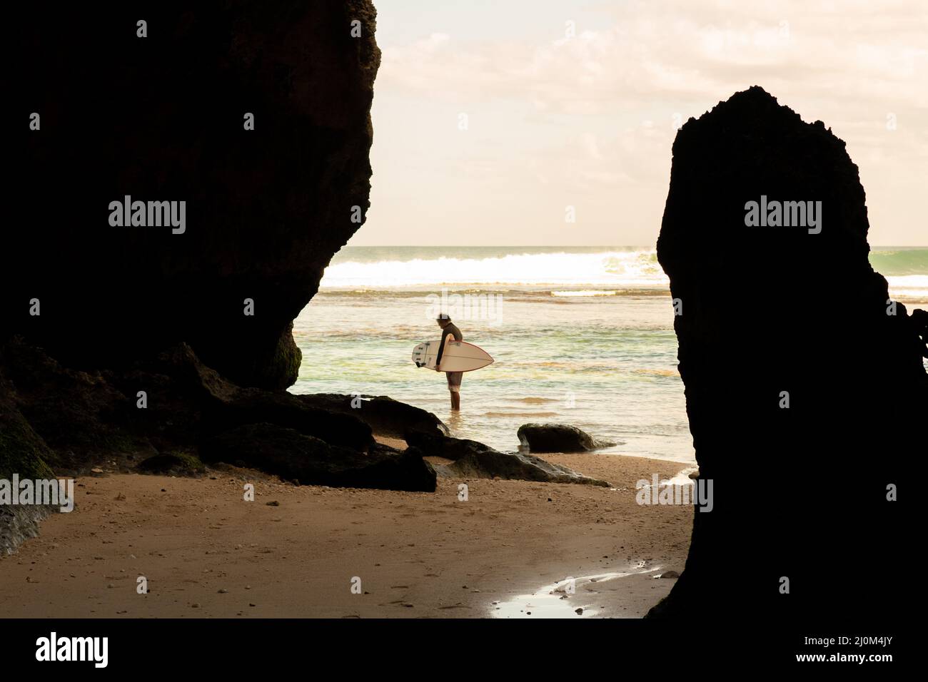 A man walking on the beach with a surfboard Stock Photo - Alamy