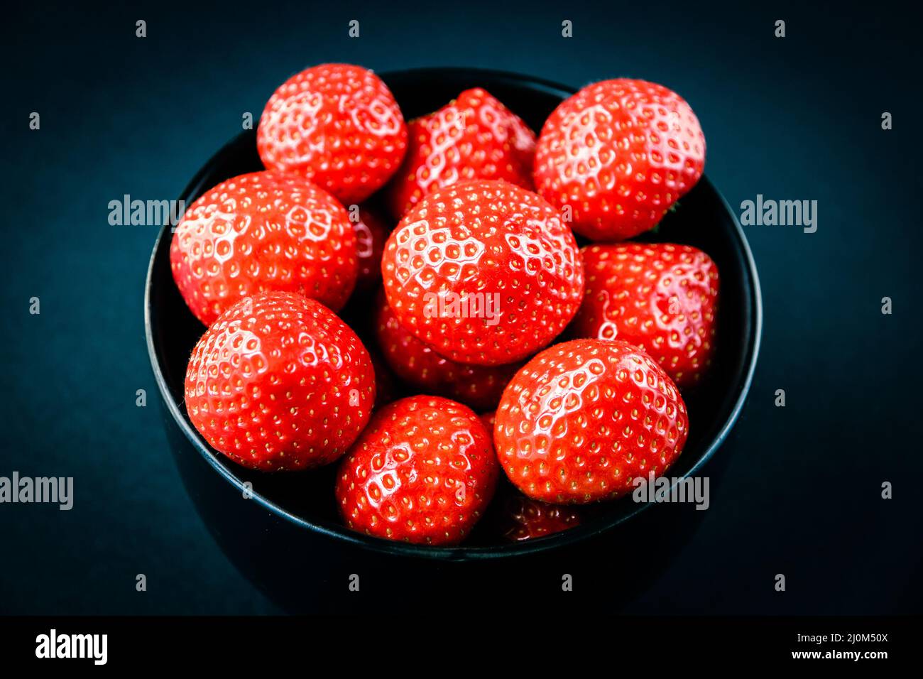 Strawberries in a bowl. Black background Stock Photo - Alamy