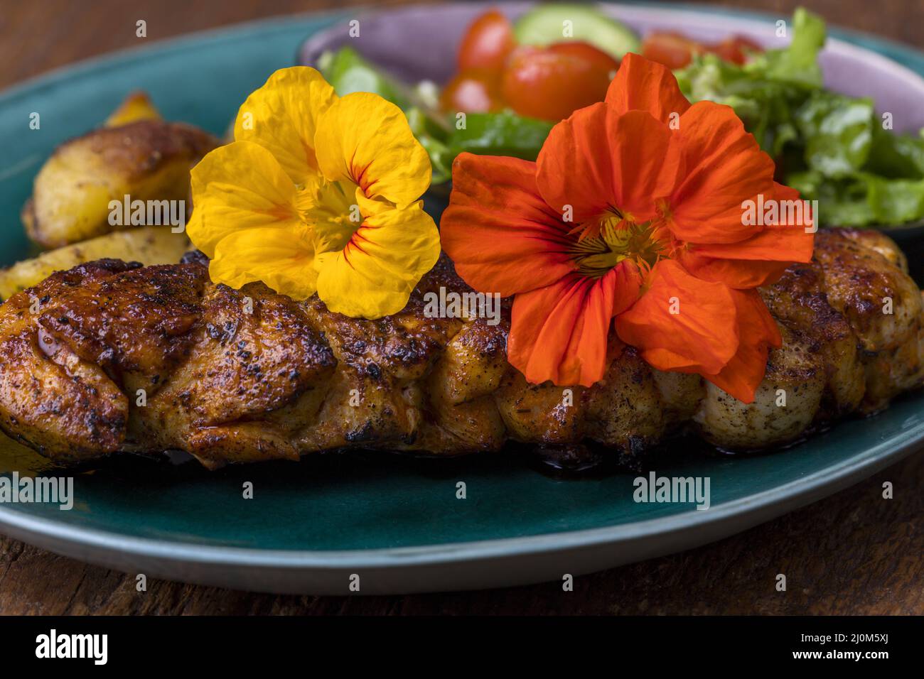 Nasturtium on a grilled steak Stock Photo