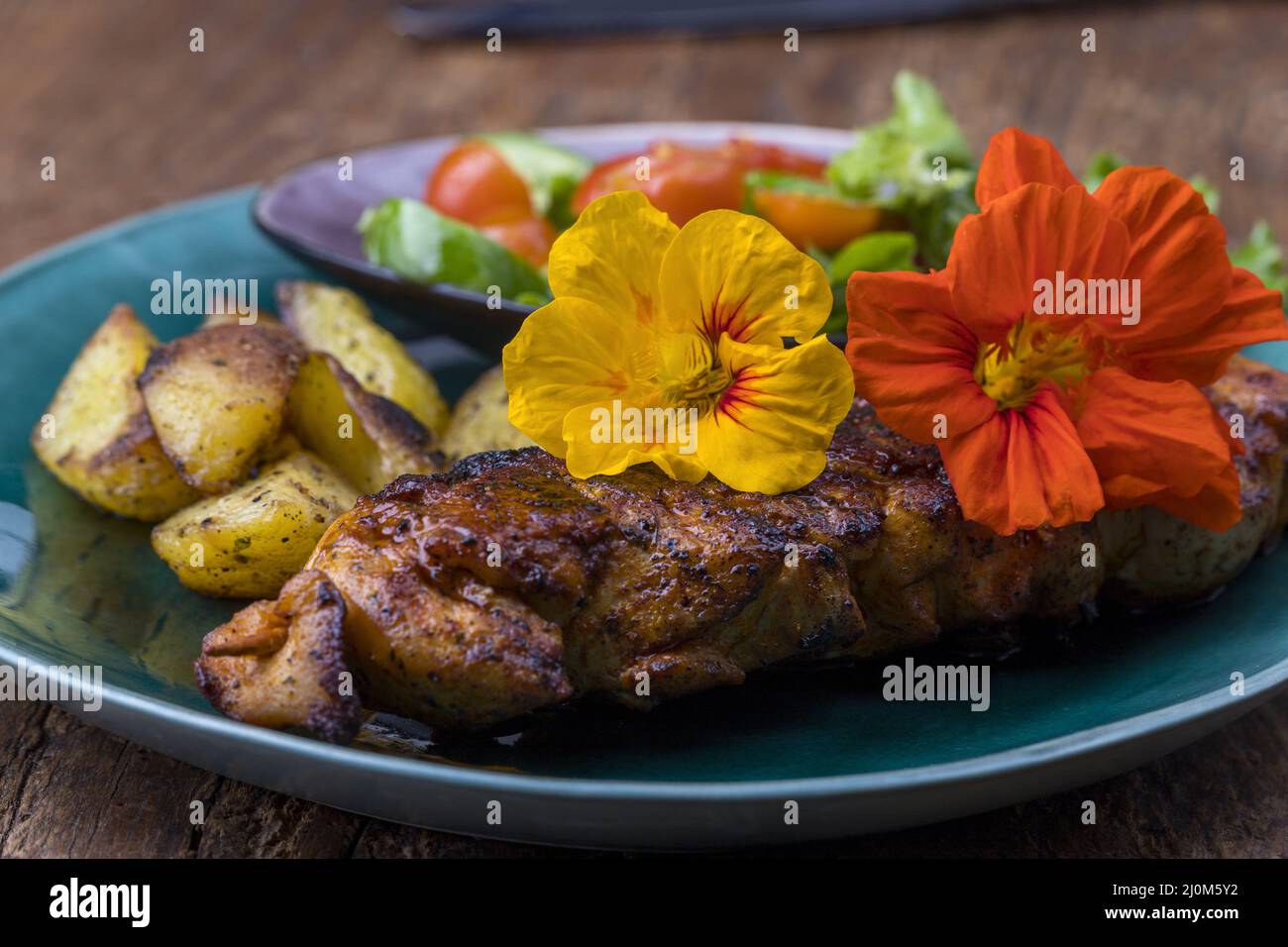 Nasturtium on a grilled steak Stock Photo