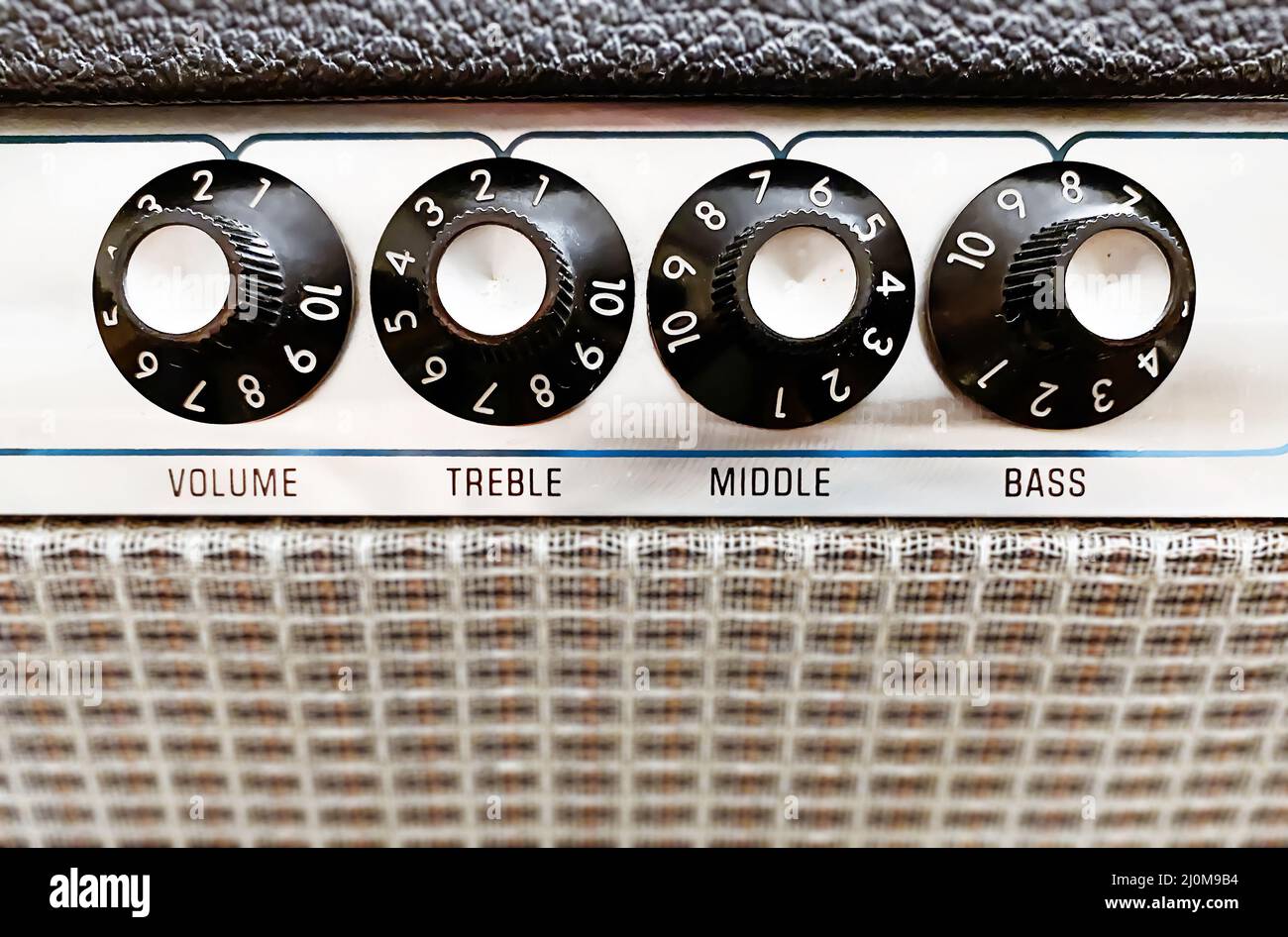 Closeup view of the knobs of an amplifier for adjusting the sound of stringed musical