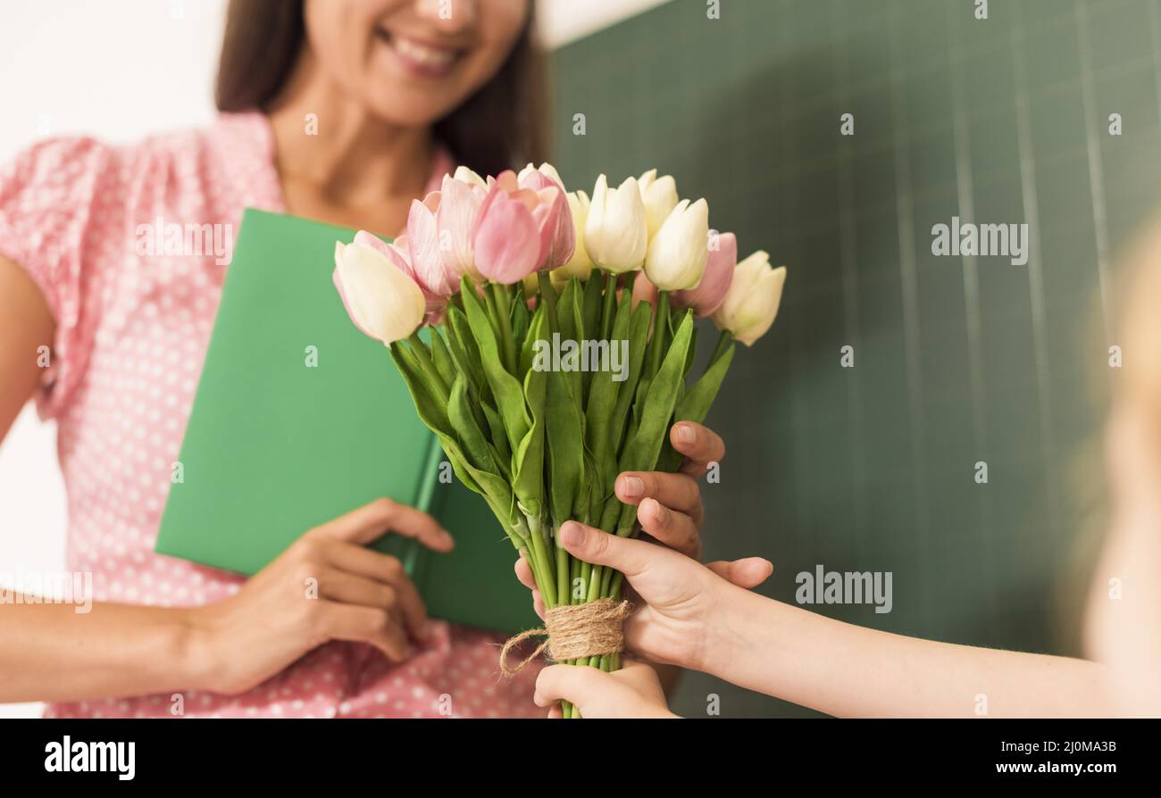Girl handing bouquet flowers her teacher Stock Photo Alamy