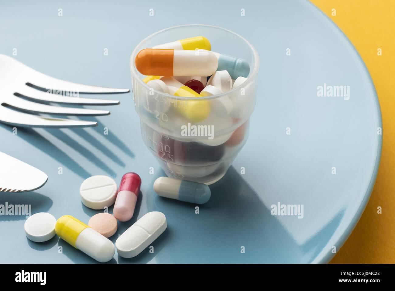 High view glass filled with pills Stock Photo