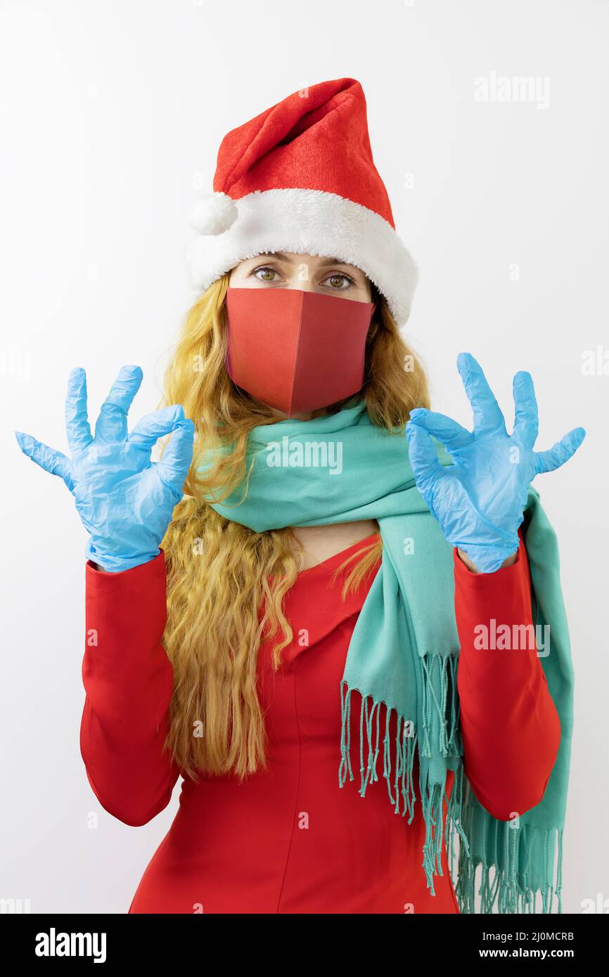 Lady Santa in protective mask and gloves shows ok gesture. Festive protection. With protection everything is OK Stock Photo