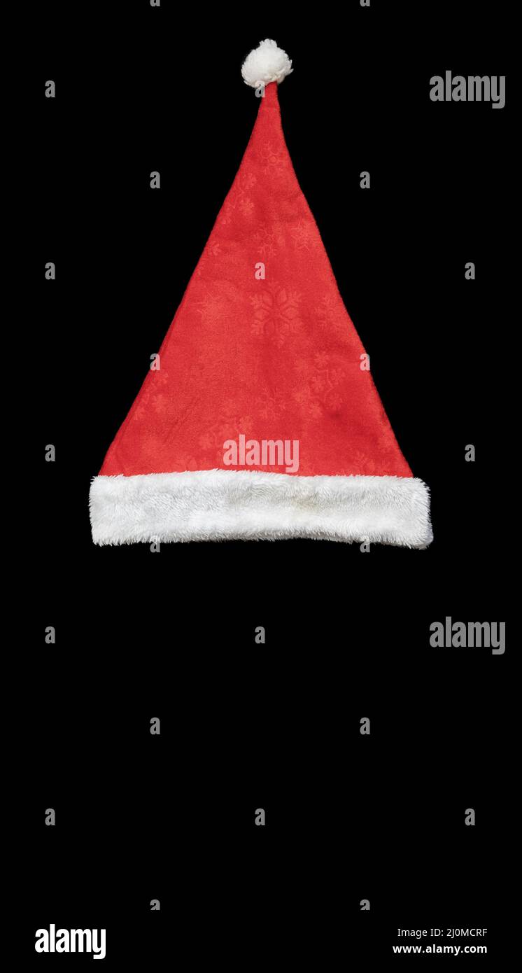 Red santa hat with white bubo and edging on a black background. Top view Stock Photo