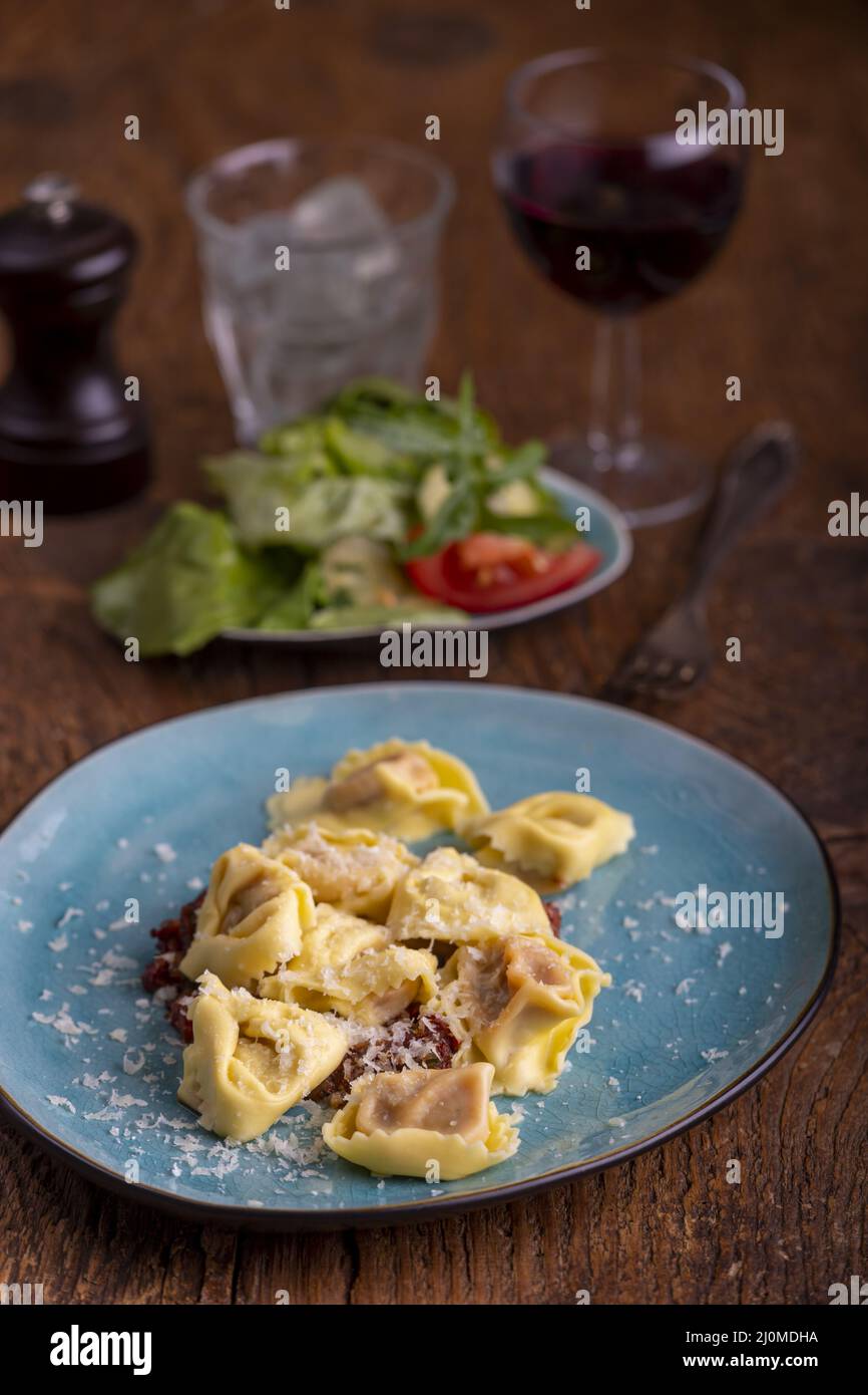 Tortellini with olive oil on blue plate Stock Photo Alamy