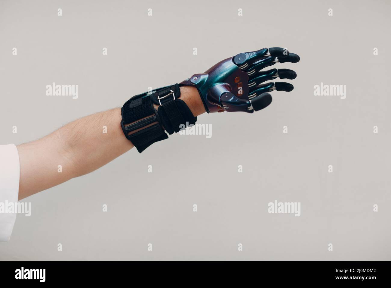 Disabled man with artificial prosthetic hand close up hand against gray ...