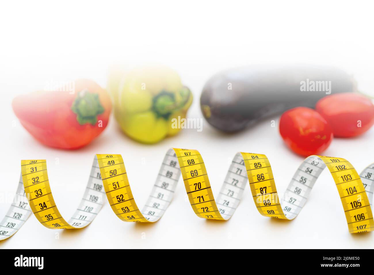 Yellow measuring tape. Fresh vegetables for healthy lifestyle diet food. Stock Photo