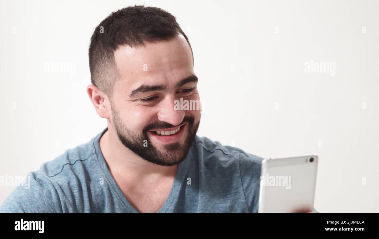 Smiling handsome man doing online shopping holding smartphone and debit or credit card. online shopping apps on smartphone. 4K f Stock Photo