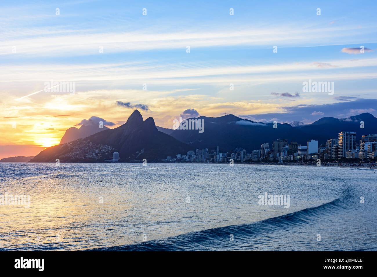 Sunset behind the mountains and sea Stock Photo