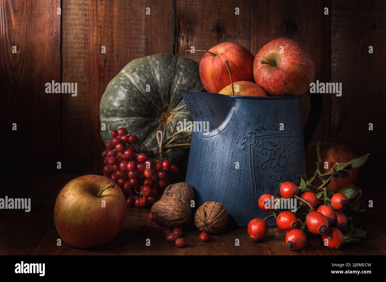 Apples in a garden jug on a dark wooden background in a rustic style Stock Photo