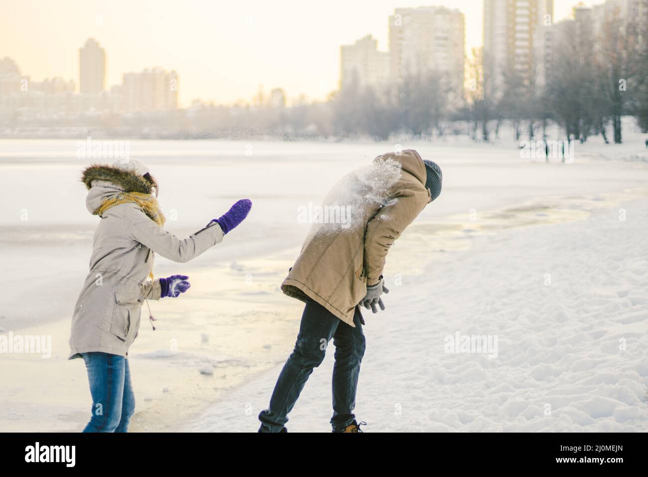 Young Caucasian people in love heterosexual couple have a date in winter near a frozen lake. Active holiday holiday Valentine's Stock Photo