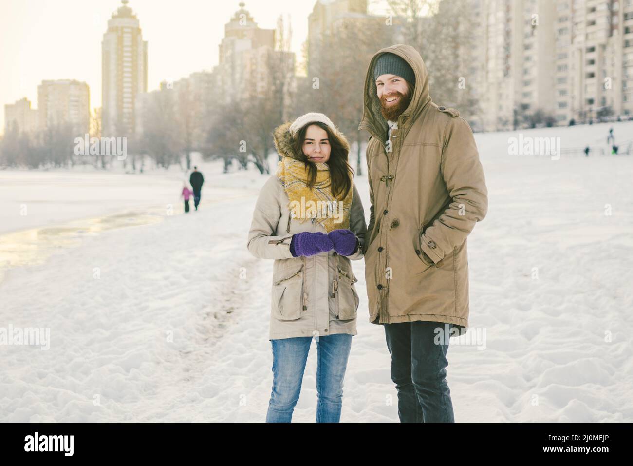 Theme love and date on nature. A young Caucasian heterosexual couple guy and girl walk in the winter along a frozen lake in wint Stock Photo