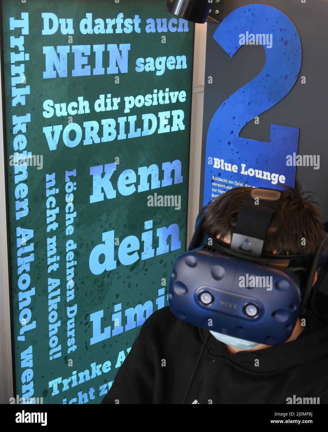 16 March 2022, Saxony, Bad Düben: In a 'happiness bus' in front of a high school in the small town in northern Saxony, young people sit in the Blue Lounge, where the effects of alcohol on various activities and perceptions can be experienced through the use of VR glasses. In the double-decker bus, which has been converted into a mobile exhibition space, children and young people can playfully explore the topics of happiness and addiction in teams at eight interactive stations. The mobile addiction prevention project GLÜCK SUCHT DICH of the Fach- und Koordinierungsstelle Suchtprävention Sachsen Stock Photo
