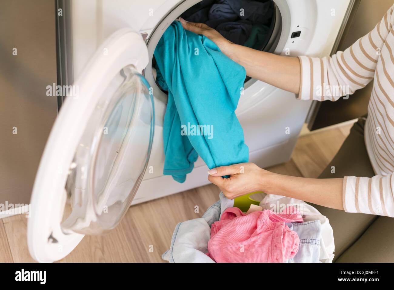 Hands taking laundry out washing machine Stock Photo Alamy