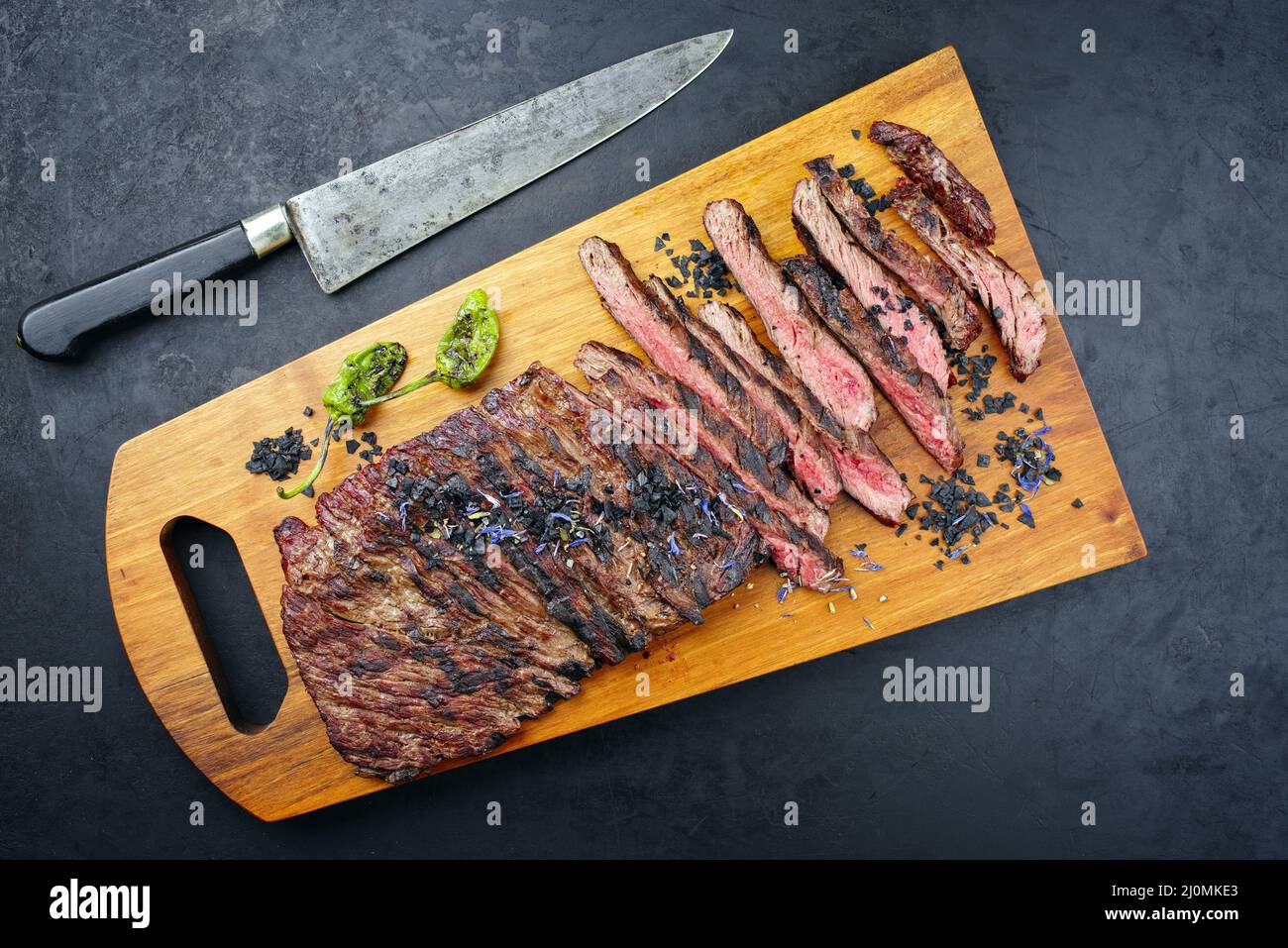 Modern style traditional barbecue wagyu bavette steak with green chili and spices served as top view on a wooden design board Stock Photo