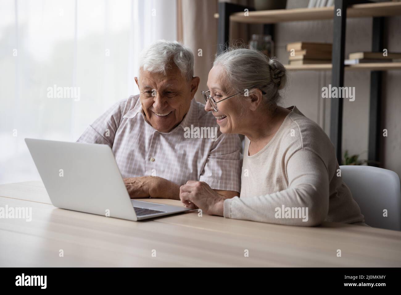 Happy older couple using laptop buying goods through e-commerce Stock Photo