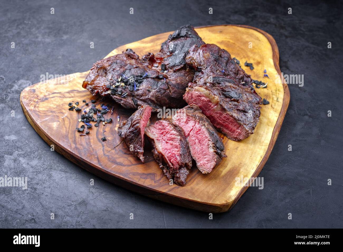 Traditional barbecue wagyu spider beef steak with black salt and spices served as close-up on a rustic wooden board with copy sp Stock Photo