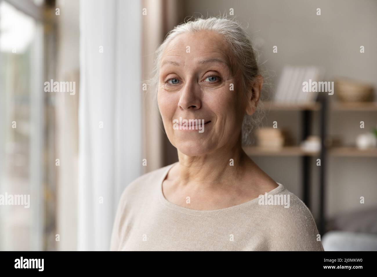 Headshot portrait attractive older woman posing indoor Stock Photo
