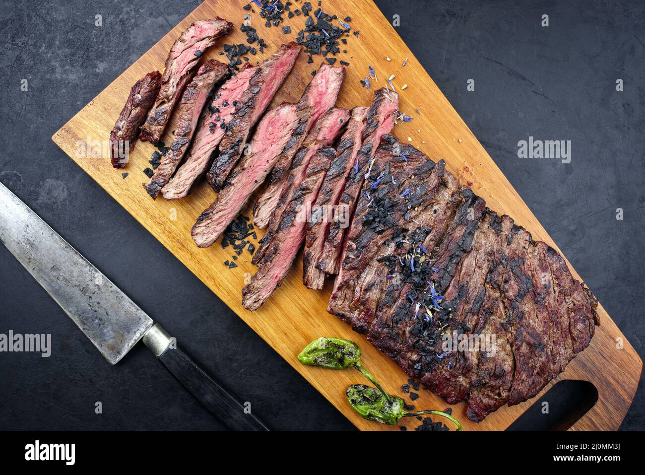 Modern style traditional barbecue wagyu bavette steak with green chili and spices served as top view on a wooden design board Stock Photo