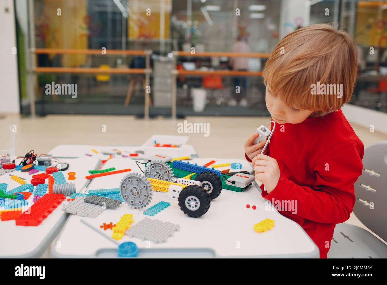 Little boy kid child constructor checking technical toy. Children Robotics constructor assemble robot. Stock Photo