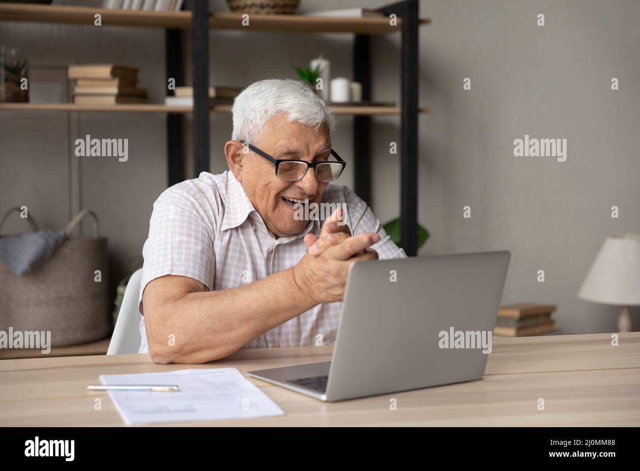 Older man read message use laptop celebrate great news Stock Photo - Alamy
